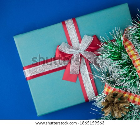 Christmas composition. Christmas gift, fir branches on a dark blue  background, top view, copy space. 