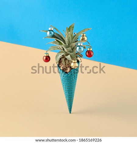 Creative minimal xmas concept. Ice cream cone with pineapple on beige and blue background. Tropical minimal beach concept