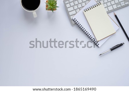 Top view above of White office desk table with keyboard, notebook and coffee cup with equipment other office supplies. Business and finance concept. Workplace, Flat lay with blank copy space.