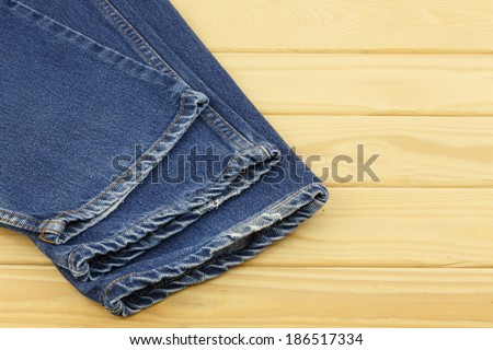 Blue jeans on wooden background