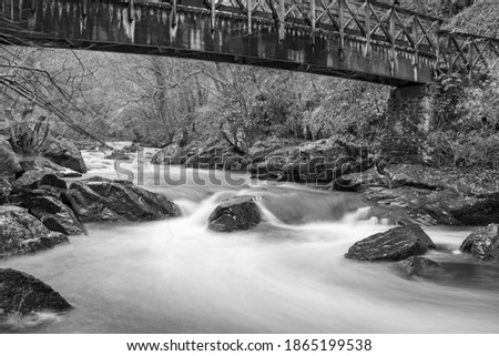 Long exposure of the East Lyn river flowing under a bridge at Watersmeet in Exmoor National Park