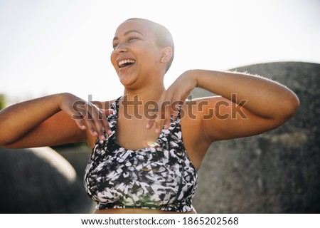 Woman smiling outdoors after workout in morning. Female in sportswear relaxing after training session. Royalty-Free Stock Photo #1865202568