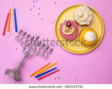 Top view image of jewish holiday Hanukkah background with traditional donuts, menorah (traditional candelabra) and candles.