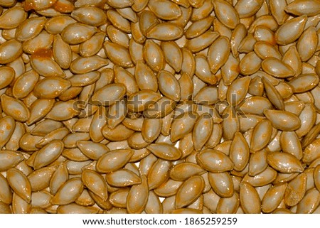 Top view of organic pumpkin wet seeds background.