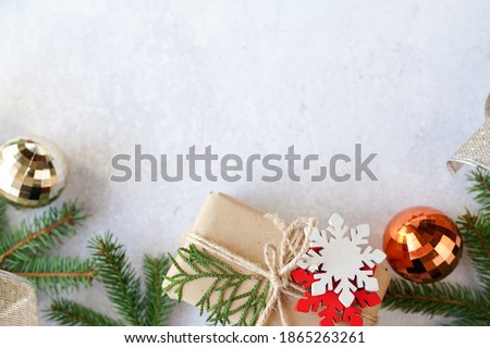 Christmas gift box with decorations on gray background, copy space