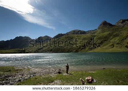 Fisher man standing in front of a lake