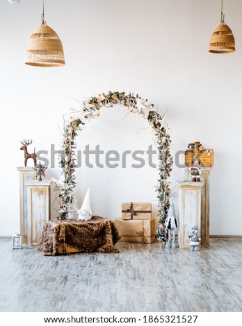 Arch on a white background decorated with spruce branches and a garland, new year's composition in the interior, a zone for a photo shoot in the Studio, room decor for Christmas