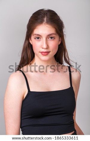Close up portrait of a young beautiful brunette model, isolated on gray background
