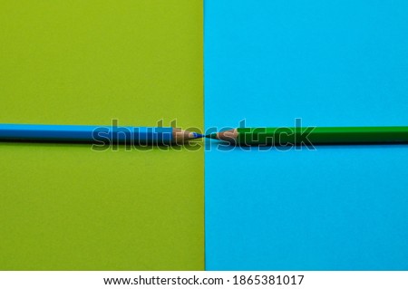 blue and green colored pencils on reverse background, conceptual photo representing the meeting