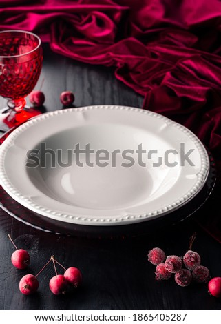 Christmas decoration table. Festive plate and cutlery with Christmas decor on retro festive table. empty white plate on the black Christmas table of copy space Free space for your text.