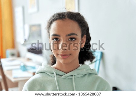 African american teen girl high school student looking at camera at home. Generation z mixed race pretty teenager standing in bedroom casual interior, headshot close up front portrait. Royalty-Free Stock Photo #1865428087