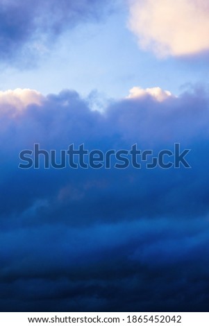 Dreamy sunset sky with vivid pink and orange fluffy clouds and sun rays running through air, storm, background. Heaven evening cloudscape after overcast day. Wallpaper with beautiful deep blue skies.