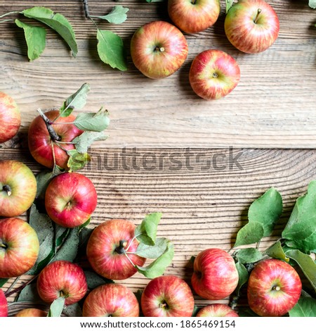 Red apples and leaves top view on wooden table
