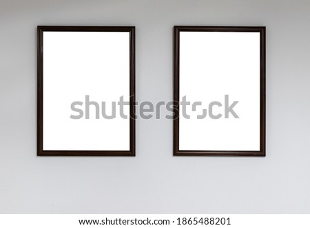 Two empty picture frames on a white wall