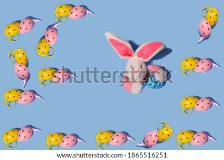 Easter background. Easter eggs pattern. In the center, a rabbit peeks out of torn paper. Horizontal, free space.