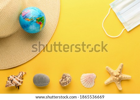 Tourist theme: hat, seashells, starfish, rock, a medical mask , the globe on a bright yellow background, center space for text. The globe shows South America, North America, USA. 
 Banner.