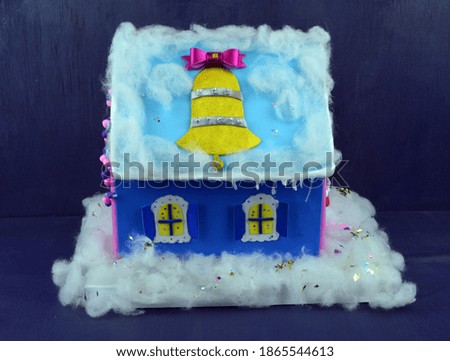 
DIY holiday house stands on a purple wooden background soft focus