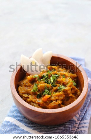 Baigan Bharta, also called Vangyache Bharit in Marathi. It is a roasted eggplant curry. Brinjal chutney. served in a wooden bowl with rice roti or tandalachi bhakri. copy space.