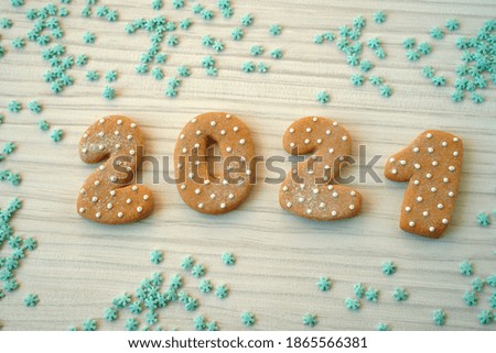  Ginger bread cookies on wooden table. Merry Christmas and Happy New Year 2021!                             