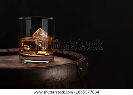 Scotch whiskey glass and old wooden barrel. With copy space Royalty-Free Stock Photo #1865577034