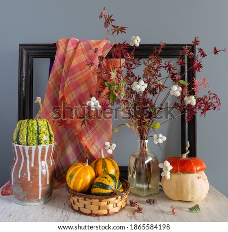 Still life with pumpkins, an autumn bouquet and a wooden frame from the picture. Vintage.