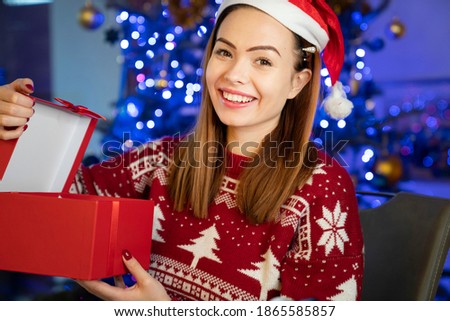 Merry Christmas. Beautiful young girl gets Christmas gifts.