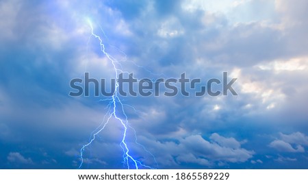 Lightning strikes between stormy clouds.