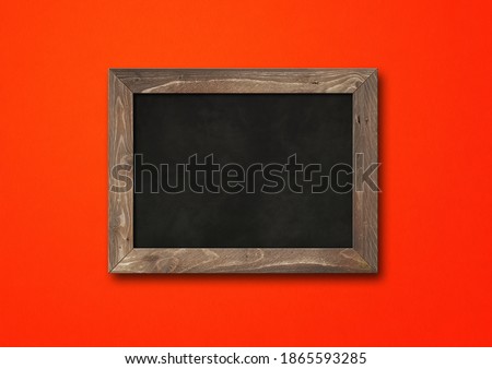 Old rustic black board isolated on a red background. Blank horizontal mockup template