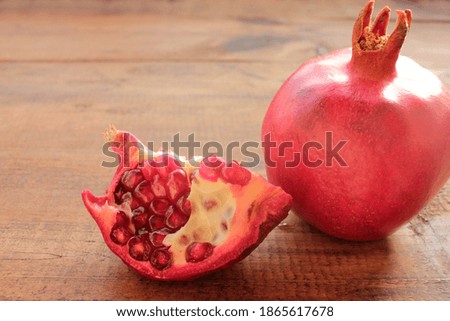 Pomegranate on wooden background. Ripe fresh red fruit on wood table. Top view, copy space