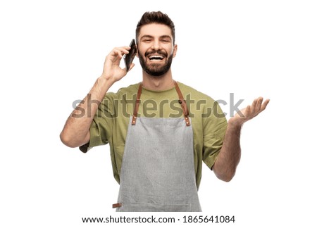 people, technology and job concept - happy smiling barman in apron calling on smartphone over white background