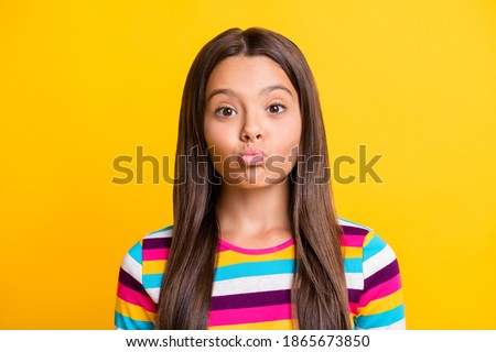 Photo of lovely little girl send air kiss you look camera wear striped shirt isolated yellow color background