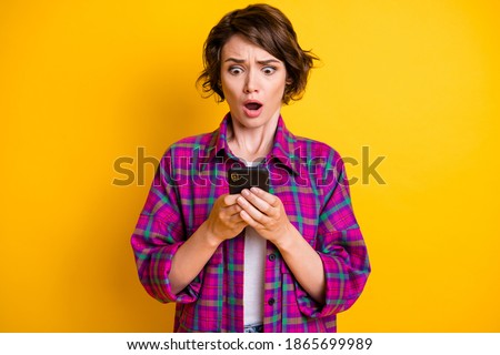 Photo of scared brown haired girl wear plaid shirt hold phone negative message comment isolated on yellow color background