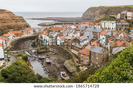 Houses clustered together in Staithes as the Roxby Beck winds through the village and empties into the sea.  Pictured during September 2020 on the North Yorkshire coast.