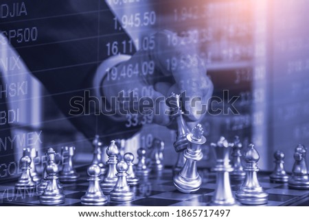 Chess game on chess board behind business man background. Business concept to present financial information and marketing strategy analysis. Investment target in global economy and digital commercial.