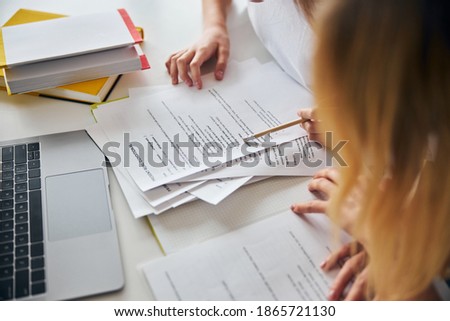 Cropped photo of a teenager passing the edge of a pencil with eraser over a sheet of paper with text