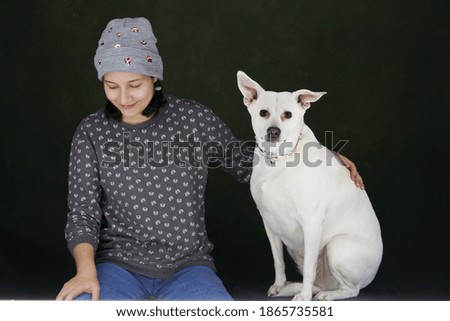Young woman with her dog, indoors portrait. Girl and white dog having fun together. Pet and owner friendship