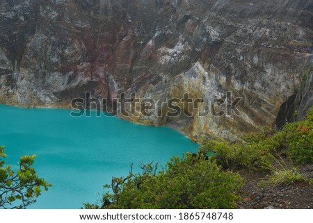 Kelimutu lake landscape from behind the cantigi trees. Beautiful view of Lake Kelimutu with a blue crater. selective focus