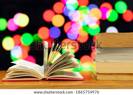 A pile of books and open book with blurred colour as background and copy space.