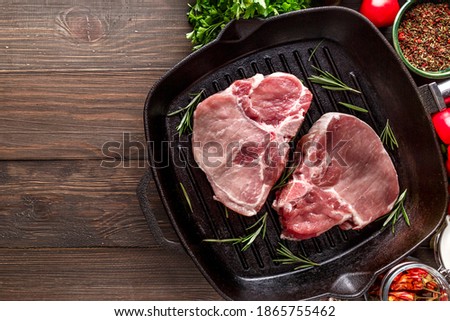 Raw Fresh Meat Steak with Ingredients and Fried Grill Frying Pan.Top view. free space for your text. Rustic style.