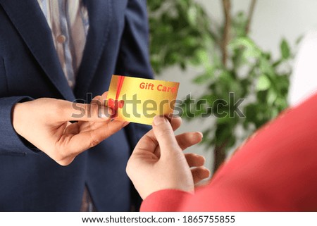 Women with gift card on blurred background, closeup 