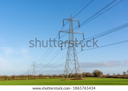 Electricity pylons in a field with blue sky. Bishop's Stortford, Hertfordshire. UK Royalty-Free Stock Photo #1865765434