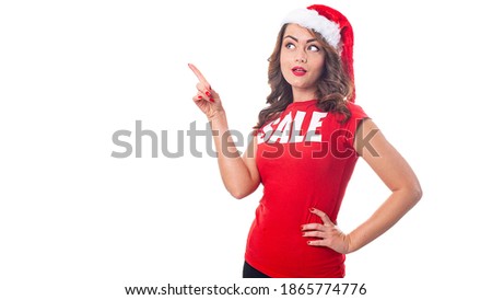 Woman in Santa hat and a red t-shirt with the inscription sale over white background with copyspace