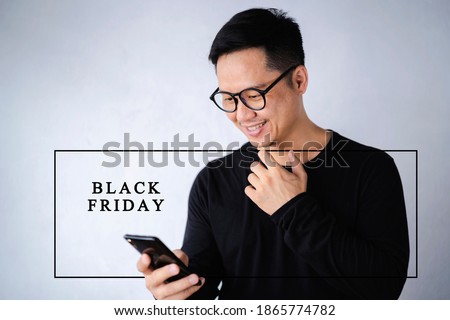 Black friday concept. Happy asian men using smart phone and smiling at home. Asian man holding and using cellphone for searching