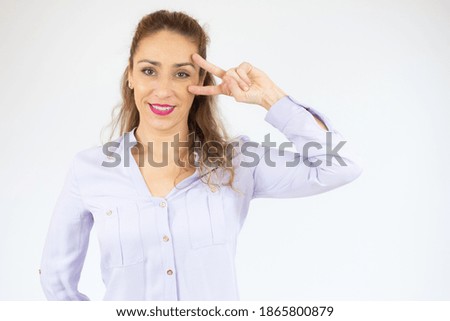Young caucasian woman isolated showing victory sign and smiling over white background.