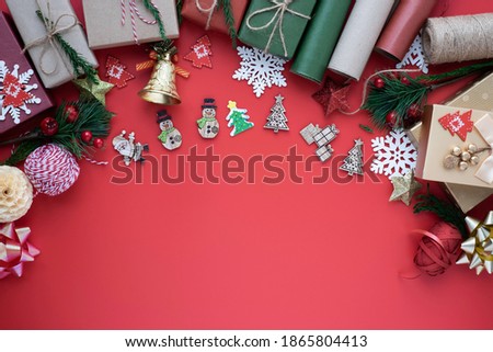Top view above of Christmas holiday background. Composition with fir pine branches, ribbon, bow and gift box decorations on red background. Winter, Christmas, new year concept. Flat lay, copy space.