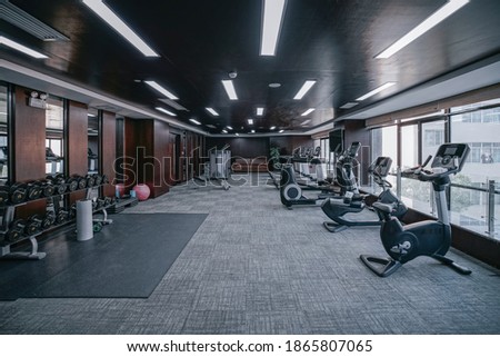 Modern light gym. Sports equipment in gym. Barbells of different weight on rack. Royalty-Free Stock Photo #1865807065