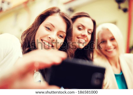 holidays and tourism concept - beautiful girls taking selfie in cafe in city