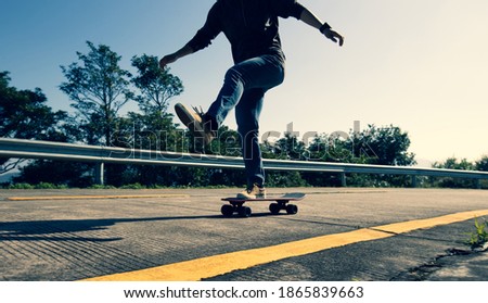 Skateboarder riding skateboard on sunrise mountain peak