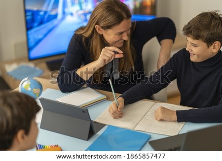 A boy gets help from his perents during an online class