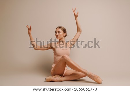 Beautiful young focused ballerina dancing gracefully on camera isolated over white background